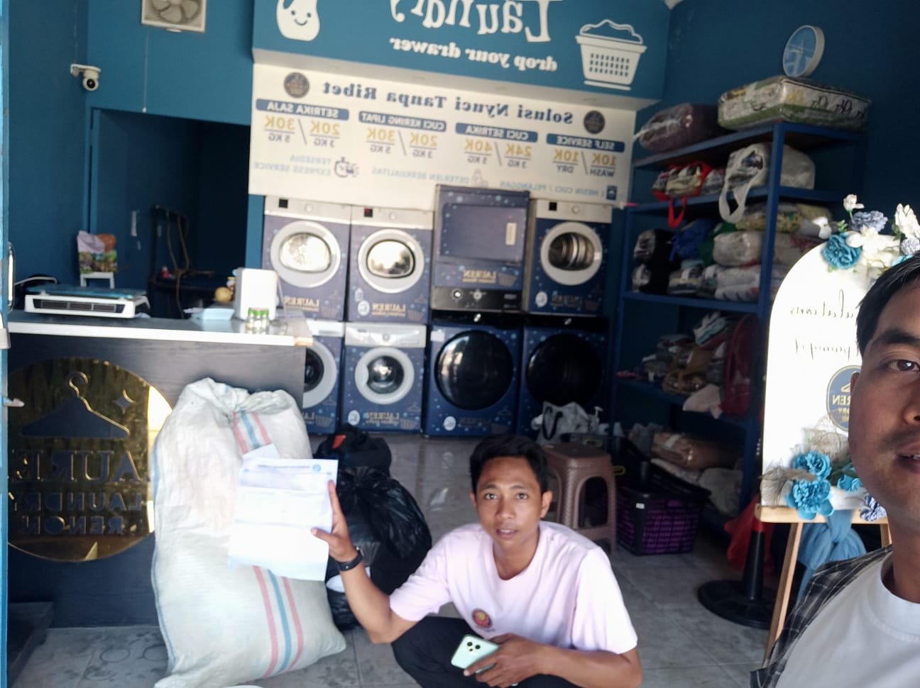 Kunjungan tim ke gerai laundry dengan mesin komersial